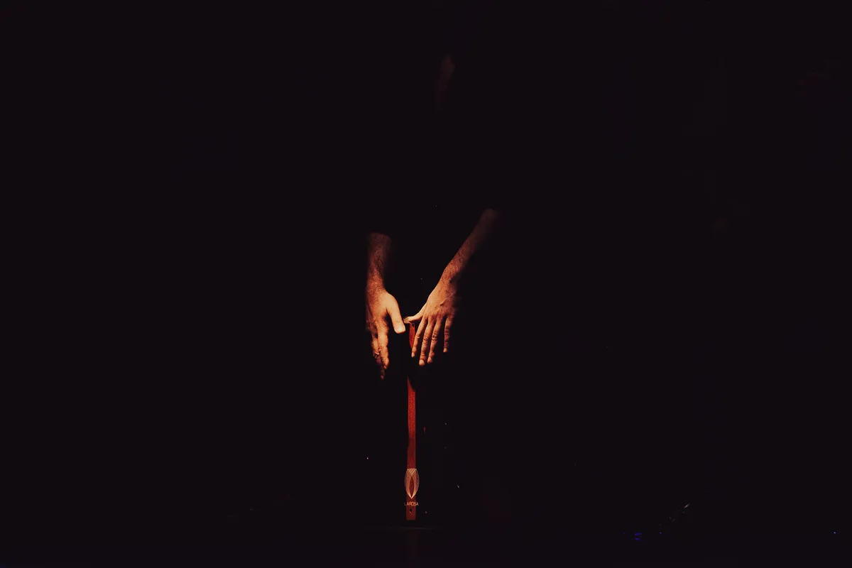 Percussionist hands resting on a cajón in the darkness of a Madrid tablao